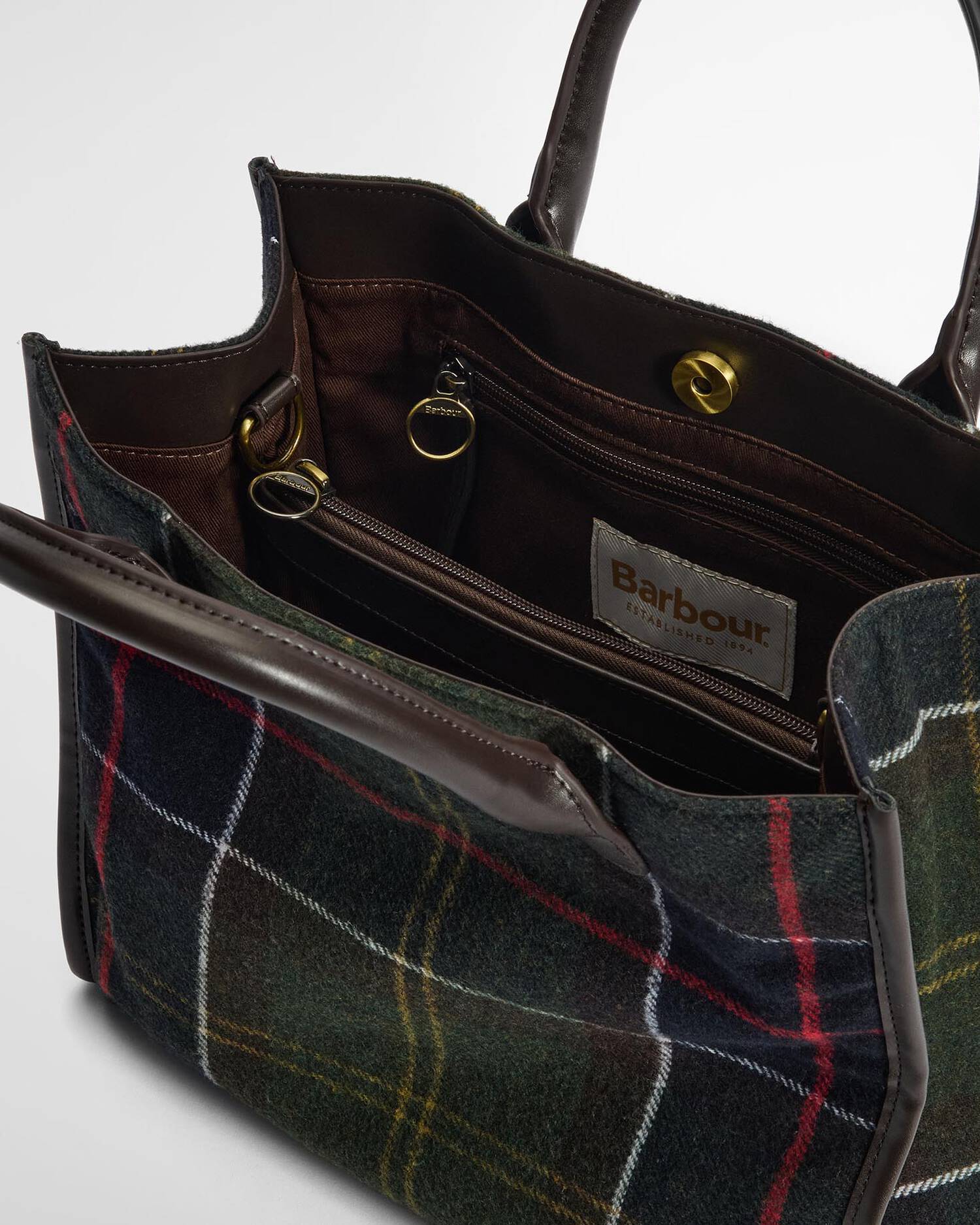 Tweed handbag with visible Barbour label on a light gray background