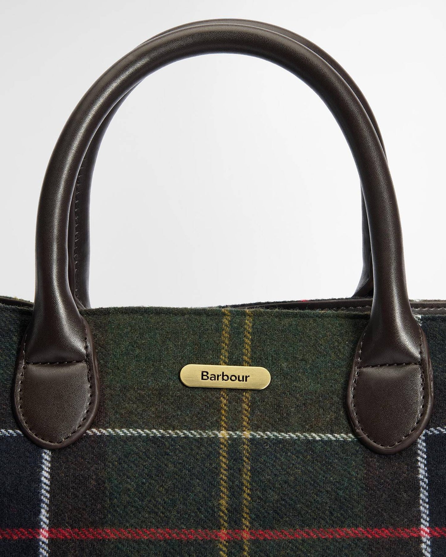 Close-up of a Barbour plaid bag with leather handles on a white background