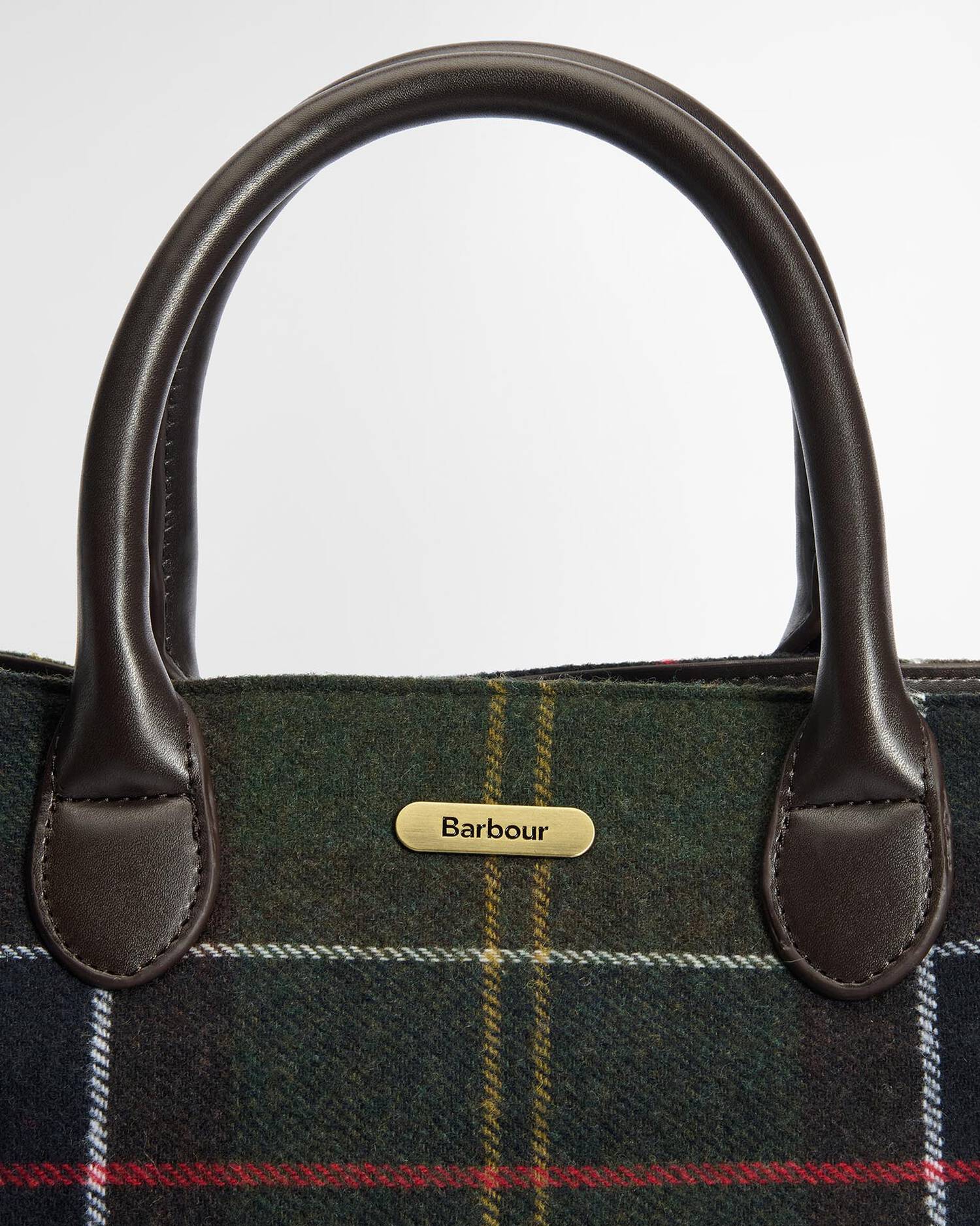Close-up of a Barbour plaid bag with leather handles on a white background