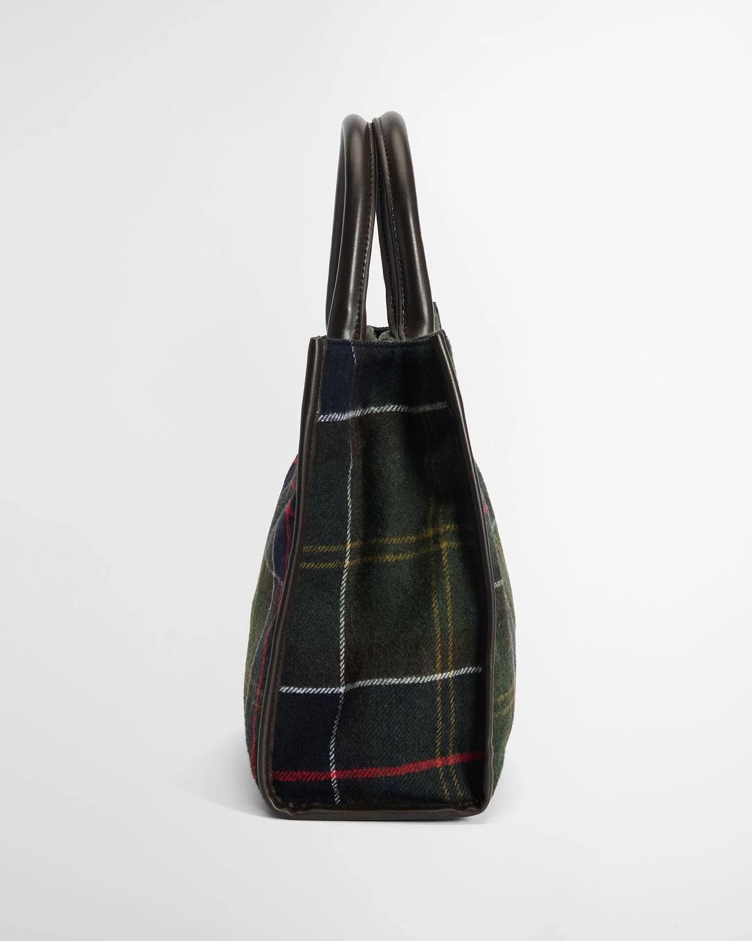A structured tartan plaid handbag in dark green, navy, and red with dark brown leather handles, shown from a side profile view on a light gray background.