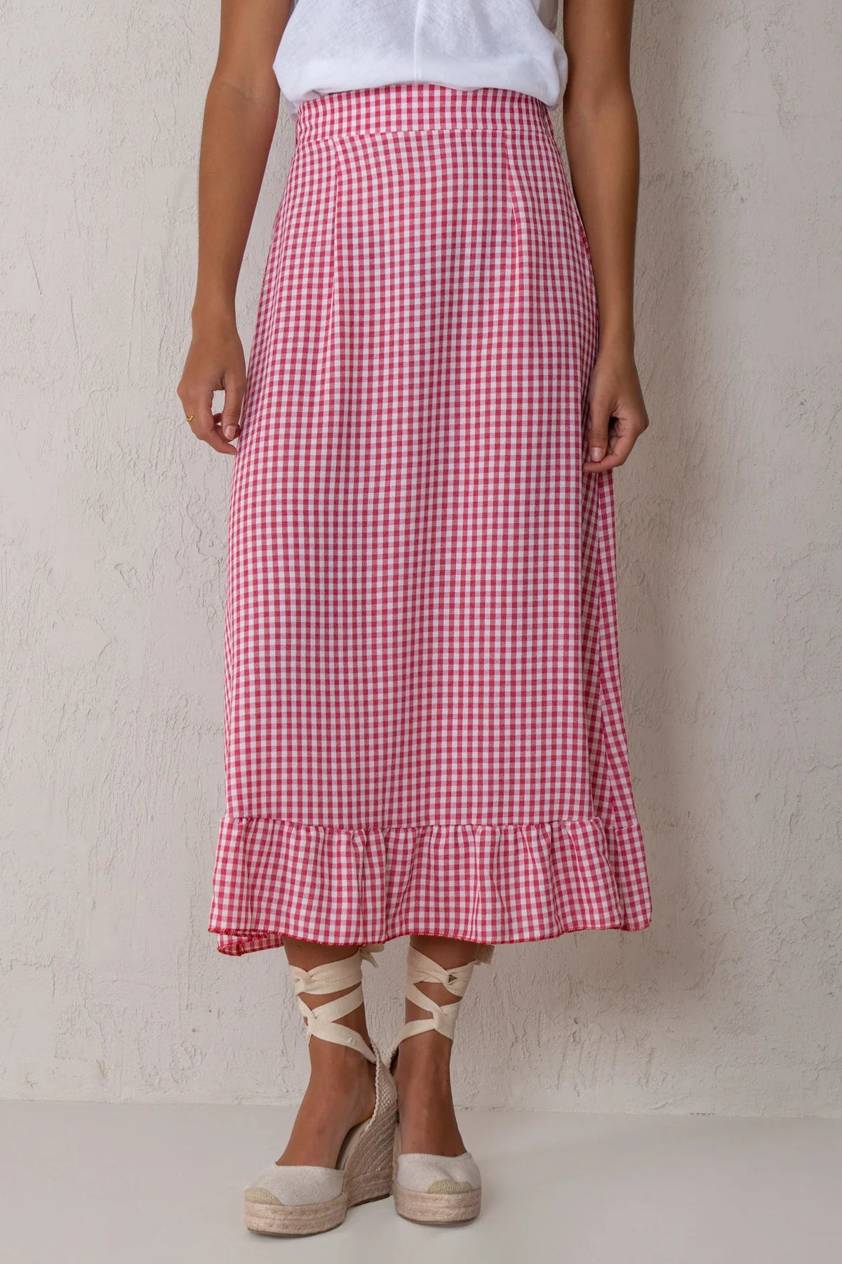 Person wearing a red and white checkered skirt on a plain background