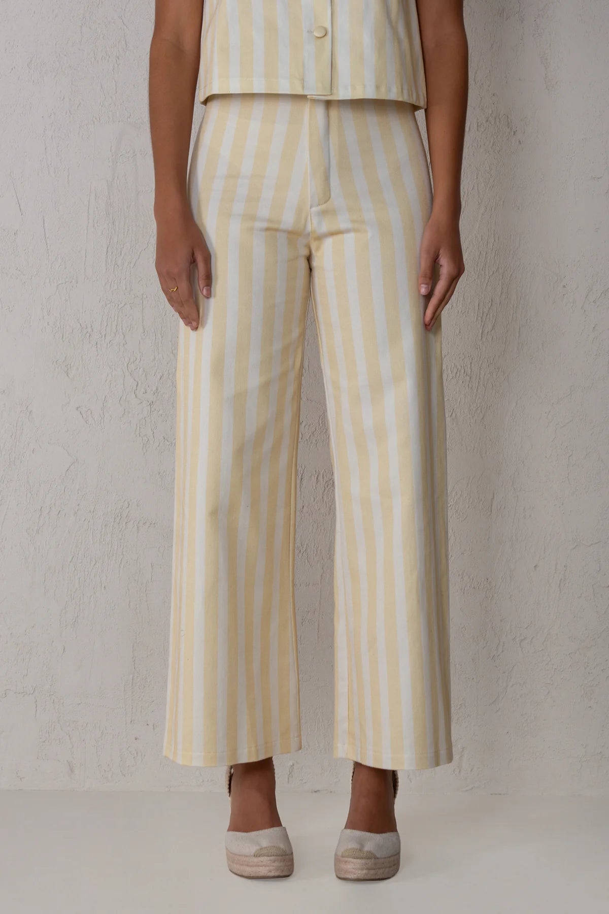 Person wearing a yellow and white striped outfit against a plain background
