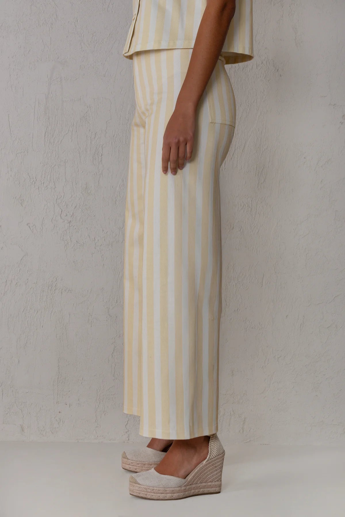 Person wearing a yellow and white striped outfit with a plain background
